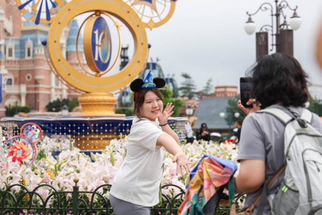 SHANGHAI, CHINA - JUNE 16: Tourists pose for photos with a floral display themed for the 10th anniversary on June 16, 2026 in Shanghai, China. Shanghai Disney Resort has welcomed over 100 million visitors since its opening.  Copyright: xVCGx 111648625139