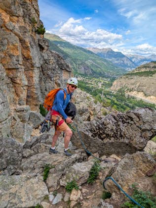 Klettern in Casse de Prelles in den französischen Alpen. Eine Person mit Kletterausrüstung auf einem felsigen Bergpfad. Alpines Bergpanorama unter einem blauen Himmel *** Climbing in Casse de Prelles,detected_source_language in the French Alps a Person with Climbing equipment at a rocky Mountain trail Alps Mountain panorama at a blue Sky 1133302996 ,model released, Symbolfoto