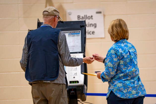 A polling operator hands a woman a stylus to vote in Washington DC s 2026 primary elections at Sherwood Recreation Center on Tuesday, June 16, 2026. The two front-runners to succeed current DC Mayor Muriel Bowser are Kenyan McDuffie, a moderate with support from many of Bowser s cabinet, and Janeese Lewis George, democratic socialist who built her campaign around organized labor.  WAP20260616315 BONNIExCASH