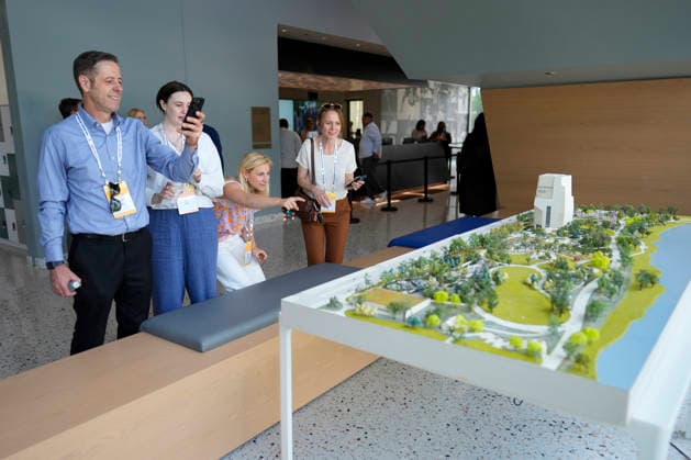 People stop to take a closer look at a scale model of the Obama Presidential Center as they arrive for a stakeholders reception that former President Barack Obama and former first lady Michelle Obama will be attending at the Obama Presidential Center, Tuesday, June 16, 2026, in Chicago, Illinois. The Obama Library officially opens to the public on Friday June 19, 2026. Pool  CHI2026061611 PabloxMartinezxMonsivais