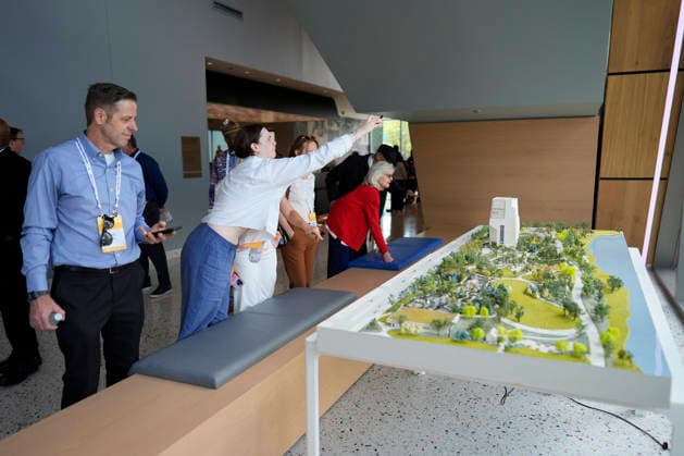 People stop to take a closer look at a scale model of the Obama Presidential Center as they arrive for a stakeholders reception that former President Barack Obama and former first lady Michelle Obama will be attending at the Obama Presidential Center, Tuesday, June 16, 2026, in Chicago, Illinois. The Obama Library officially opens to the public on Friday June 19, 2026. Pool  CHI2026061612 PabloxMartinezxMonsivais