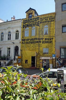 Der Buchladen Golden Shop im Bremer Steintorviertel hat im Juni 2026 seine gelbe, mit schwarzen Sprüchen bemalte Fassade mit einem Transparent verhüllt, das in derselben Gestaltung angebliche Zitate von Kulturstaatsminister Wolfram Weimer wiedergibt. Damit reagiert die linke Buchhandlung auf die Entscheidung des konservativen Politikers, ihr nicht den Deutschen Buchhandlungspreis zu verleihen, obwohl eine Jury die Buchhandlung dafür auserwählt hatte. Als Begründung erwähnte er nicht näher erläuterte Erkenntnisse des Verfassungsschutzes. Auf dem Transparent steht auch eine Strophe aus einem Gedichtband namens Kopfpilz, den Weimer als junger Mann 1986 im Eigenverlag veröffentlichte: Morgen, Rentner, wirds was geben. Morgen kommt der