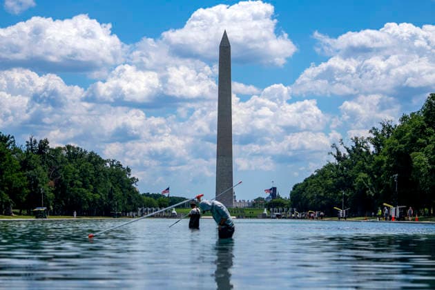 U.S. National Park Service employees use a vacuum pump to clean algae off the bottom of the newly repainted Lincoln Memorial Reflecting Pool on the National Mall in Washington, DC on Wednesday, June 17, 2026. The Trump Administration spent $16 million to paint the bottom of the pool American flag blue and as part of an effort to repair Washington landmarks in for preparation the country s 250th birthday this summer.  WAP20260617300 BONNIExCASH