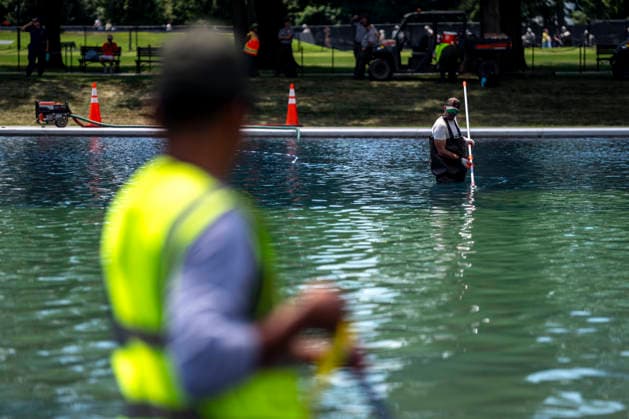 U.S. National Park Service employees uses a vacuum pump to clean algae off the bottom of the newly repainted Lincoln Memorial Reflecting Pool on the National Mall in Washington, DC on Wednesday, June 17, 2026. The Trump Administration spent $16 million to paint the bottom of the pool American flag blue and as part of an effort to repair Washington landmarks in for preparation the country s 250th birthday this summer.  WAP20260617306 BONNIExCASH