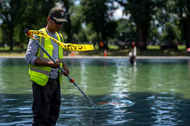 U.S. National Park Service employees use a vacuum pump to clean algae off the bottom of the newly repainted Lincoln Memorial Reflecting Pool on the National Mall in Washington, DC on Wednesday, June 17, 2026. The Trump Administration spent $16 million to paint the bottom of the pool American flag blue and as part of an effort to repair Washington landmarks in for preparation the country s 250th birthday this summer.  WAP20260617307 BONNIExCASH