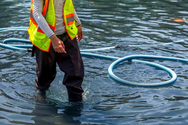 U.S. National Park Service employees use a vacuum pump to clean algae off the bottom of the newly repainted Lincoln Memorial Reflecting Pool on the National Mall in Washington, DC on Wednesday, June 17, 2026. The Trump Administration spent $16 million to paint the bottom of the pool American flag blue and as part of an effort to repair Washington landmarks in for preparation the country s 250th birthday this summer.  WAP20260617316 BONNIExCASH