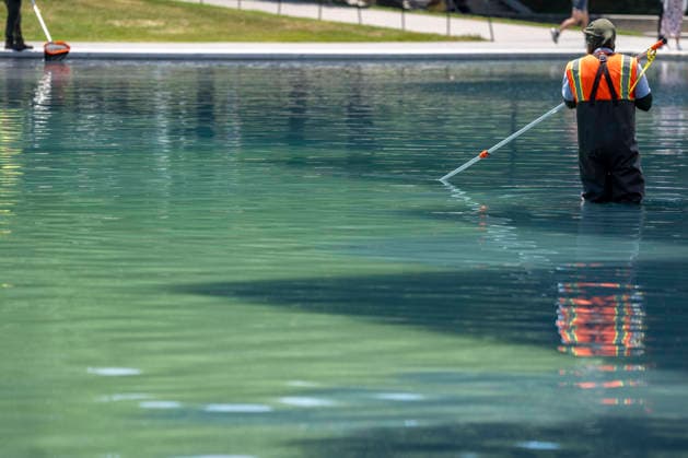 A U.S. National Park Service employee uses a vacuum pump to clean algae off the bottom of the newly repainted Lincoln Memorial Reflecting Pool on the National Mall in Washington, DC on Wednesday, June 17, 2026. The Trump Administration spent $16 million to paint the bottom of the pool American flag blue and as part of an effort to repair Washington landmarks in for preparation the country s 250th birthday this summer.  WAP20260617323 BONNIExCASH
