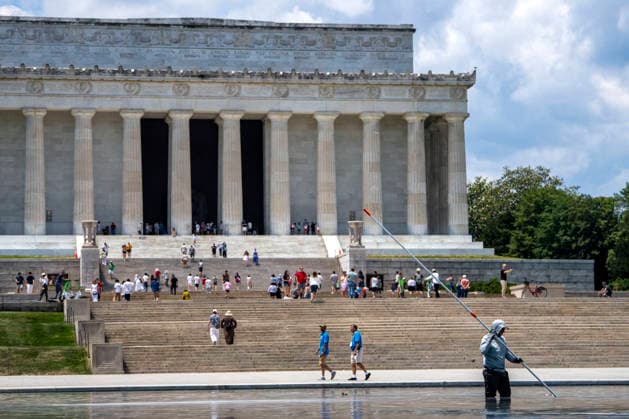 A U.S. National Park Service employee uses a vacuum pump to clean algae off the bottom of the newly repainted Lincoln Memorial Reflecting Pool on the National Mall in Washington, DC on Wednesday, June 17, 2026. The Trump Administration spent $16 million to paint the bottom of the pool American flag blue and as part of an effort to repair Washington landmarks in for preparation the country s 250th birthday this summer.  WAP20260617325 BONNIExCASH