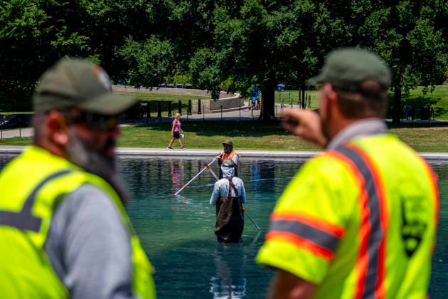 U.S. National Park Service employees use a vacuum pump to clean algae off the bottom of the newly repainted Lincoln Memorial Reflecting Pool on the National Mall in Washington, DC on Wednesday, June 17, 2026. The Trump Administration spent $16 million to paint the bottom of the pool American flag blue and as part of an effort to repair Washington landmarks in for preparation the country s 250th birthday this summer.  WAP20260617326 BONNIExCASH