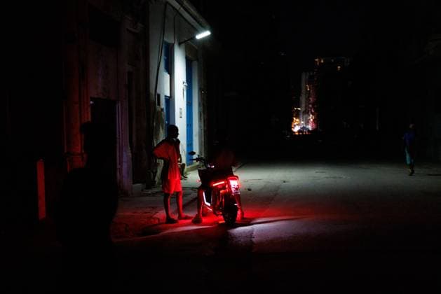 CUBA-HAVANA SOCIAL CRISIS AND WORLD CUP HAVANA, CUBA - JUNE 16, 2026: Locals stand near a motorbike with its taillight on to provide minimal illumination on an unlit street during a blackout in Central Havana, Cuba, on June 16, 2026. The worsening energy crisis requires citizens to use vehicle lights and battery-powered devices to secure safety and visibility in public zones at night. (Photo by Pablo Miranzo JNA Press via Nexpher Images) HAVANA