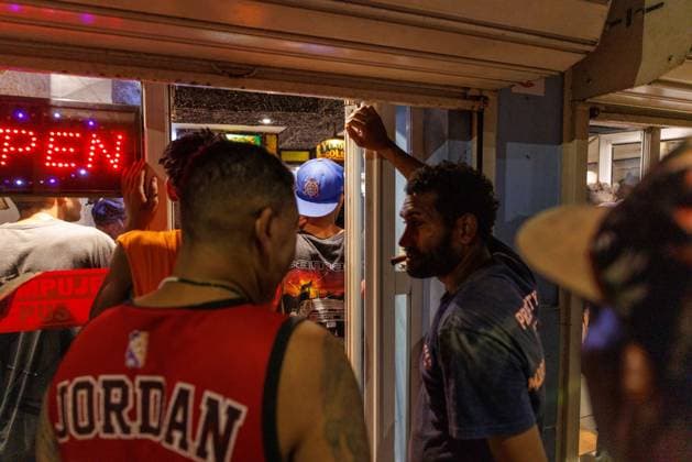 CUBA-HAVANA SOCIAL CRISIS AND WORLD CUP HAVANA, CUBA - JUNE 16, 2026: People gather near the entrance of a brightly lit commercial establishment to watch the Argentina versus Algeria World Cup match on a television screen in Havana, Cuba, on June 16, 2026. Businesses with stable electricity or independent generators become popular viewing points for the neighborhood during matches. (Photo by Pablo Miranzo JNA Press via Nexpher Images) HAVANA