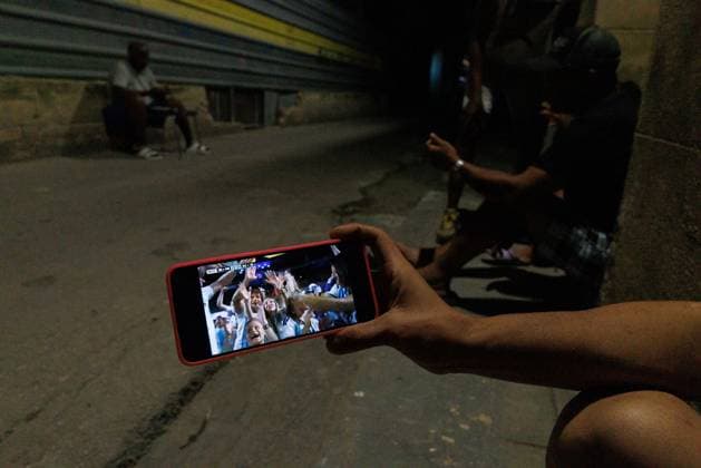 CUBA-HAVANA SOCIAL CRISIS AND WORLD CUP HAVANA, CUBA - JUNE 16, 2026: A resident uses a smartphone to watch the World Cup match between Argentina and Algeria on a dark street corner in Old Havana, Cuba, on June 16, 2026. When home televisions are cut off by rolling blackouts, sports fans rely on mobile data networks to follow live broadcasts. (Photo by Pablo Miranzo JNA Press via Nexpher Images) HAVANA