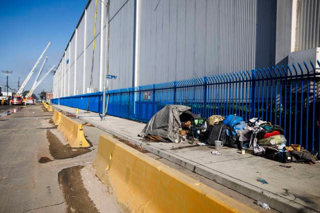Boyle Heights Warehouse Fire A homeless individual is seen as Los Angeles Fire Department crews work to contain a fire at a Boyle Heights cold storage facility involving solar panels in Los Angeles, California, on June 17, 2026. The fire prompts a smoke advisory and a shelter-in-place for the immediate area. Los Angeles California United States  Copyright: xMatthewxHoenx originalFilename: hoen-boylehei260617_np4Y7.jpg