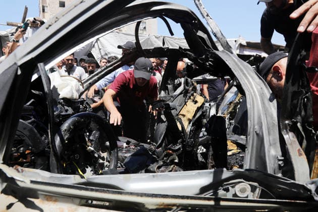 Palestinians Gather at Site of Deadly Vehicle Strike in Gaza City Palestinians and Civil Defense personnel gather around a destroyed vehicle that was targeted in an Israeli airstrike in Gaza City, on June 18, 2026. The strike killed three Palestinians, according to medical sources, and caused significant damage to the vehicle. Photo by Belal Osama apaimages Gaza Gaza Strip Palestinian Territory 180626_Gaza_BO_1_00(34) Copyright: xapaimagesxBelalxOsamax xapaimagesx