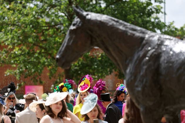 18.06.2026, Ascot, Windsor, GBR - Fashion on Ladies Day: Elegantly dressed people with hats at the racecourse. Ascot racecourse. (Zuschauer, Besucher, Publikum, Frauen, Huete, Kopfbedeckungen, Fashion, Eleganz, elegant, Mode, modisch, Maenner, Zylinder, Menschenmenge, Zuschauermenge, Pferdestatue) 260618D524ROYAL_ASCOT.JPG *** June 18, 2026, Ascot, Windsor, GBR Fashion on Ladies Day