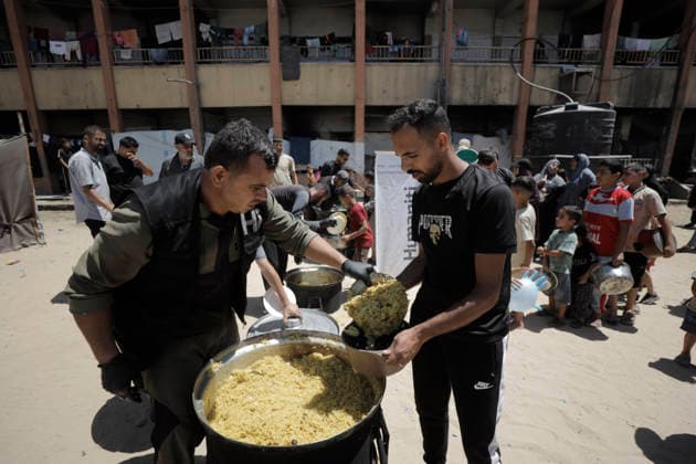 Jabalia Gaza Strip Displacement Crisis A volunteer serves food aid to displaced Palestinians at the Al-Faluja School shelter in Jabalia, in the northern Gaza Strip, on June 18, 2026. Thousands of displaced families in northern Gaza rely on humanitarian assistance as shortages of food, water and basic supplies persist amid the continuing conflict and humanitarian crisis. Gaza Gaza Strip Palestinian Territories Copyright: xAhmedxAlxArinix