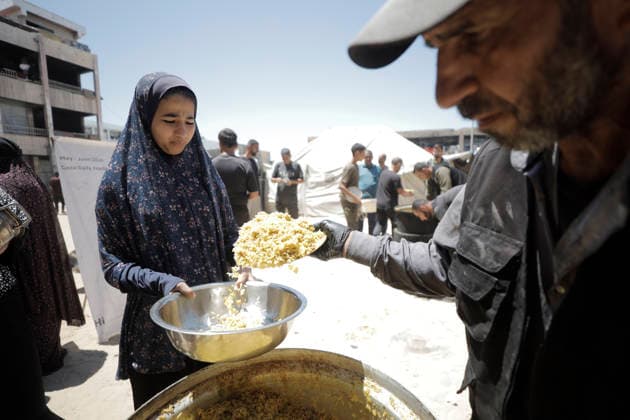 Jabalia Gaza Strip Displacement Crisis A volunteer serves food aid to displaced Palestinians at the Al-Faluja School shelter in Jabalia, in the northern Gaza Strip, on June 18, 2026. Thousands of displaced families in northern Gaza rely on humanitarian assistance as shortages of food, water and basic supplies persist amid the continuing conflict and humanitarian crisis. Gaza Gaza Strip Palestinian Territories Copyright: xAhmedxAlxArinix