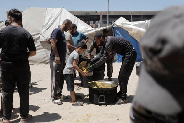 Jabalia Gaza Strip Displacement Crisis A volunteer serves food aid to displaced Palestinians at the Al-Faluja School shelter in Jabalia, in the northern Gaza Strip, on June 18, 2026. Thousands of displaced families in northern Gaza rely on humanitarian assistance as shortages of food, water and basic supplies persist amid the continuing conflict and humanitarian crisis. Gaza Gaza Strip Palestinian Territories Copyright: xAhmedxAlxArinix