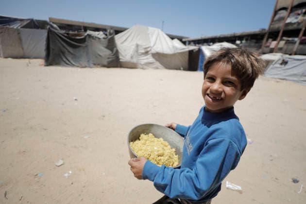 Jabalia Gaza Strip Displacement Crisis A displaced Palestinian boy carries a pot of food aid at the Al-Faluja School shelter in Jabalia, in the northern Gaza Strip, on June 18, 2026. Thousands of displaced families in northern Gaza rely on humanitarian assistance as shortages of food, water and basic supplies persist amid the continuing conflict and humanitarian crisis. Gaza Gaza Strip Palestinian Territories Copyright: xAhmedxAlxArinix