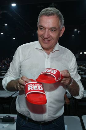 10. Bundesparteitag der Partei Die Linke am 19.06.2026 in der Metropolis Halle in Potsdam Hallenrundgang mit den Parteivorsitzenden Jan van Aken ( Parteivorsitzender Die Linke ) zeigt Badelatschen mit der Aufschrift: Walking Red *** 10th National Party Convention of Die Linke on June 19, 2026, at the Metropolis Halle in Potsdam; a tour of the venue with party chair Jan van Aken, who shows off a pair of flip-flops bearing the inscription Walking Red ,detected_source_language xRx