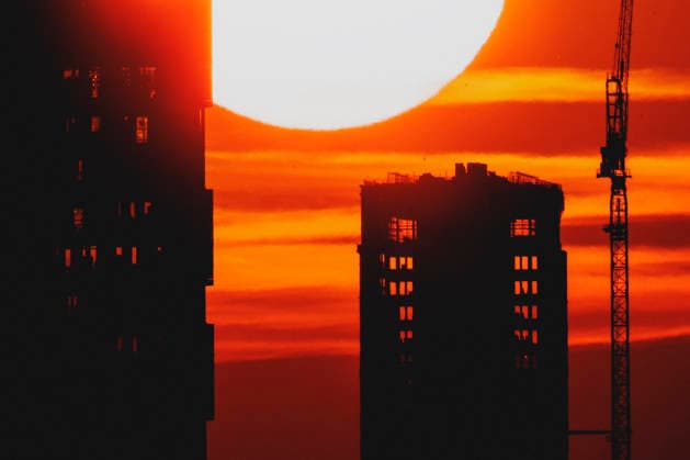 Die untergehende Sonne zeichnet sich ab hinter einem Neubau mit Kran in Berlin, 19.06.2026. In ganz Deutschland herrscht aktuell eine Hitzewelle. Berlin Deutschland *** The setting sun is visible behind a new building with a crane in Berlin, June 19, 2026. A heat wave is currently affecting all of Germany. Berlin, Germany,detected_source_language Copyright: xFlorianxGaertnerx