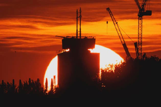 Die untergehende Sonne zeichnet sich ab hinter einem Neubau mit Kran in Berlin, 19.06.2026. In ganz Deutschland herrscht aktuell eine Hitzewelle. Berlin Deutschland *** The setting sun is visible behind a new building with a crane in Berlin, June 19, 2026. A heat wave is currently affecting all of Germany. Berlin, Germany,detected_source_language Copyright: xFlorianxGaertnerx