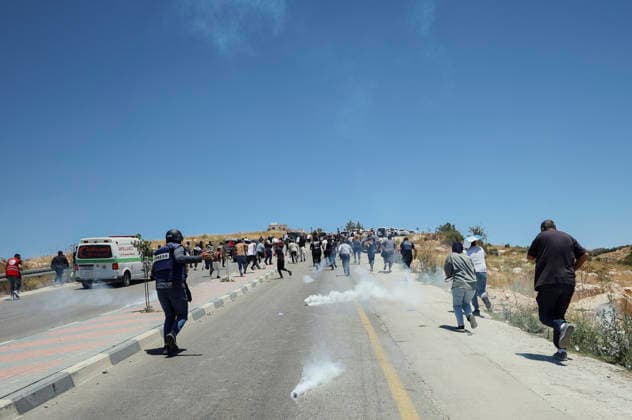 Protest Against Settlers in Dura Palestinian men and journalists run as tear gas canisters fall from the sky over a road in Jabal Tarousa near Dura, south of Hebron, in the occupied West Bank, on June 19, 2026. Palestinians held Friday prayers to protest the establishment of a newly built Israeli settlement outpost and the seizure of land. Israeli forces fired tear gas to suppress the gathering, allegedly causing several people, including journalists, to suffer from inhalation. Dura West Bank Palestinian Territories Copyright: xMosabxShawerx