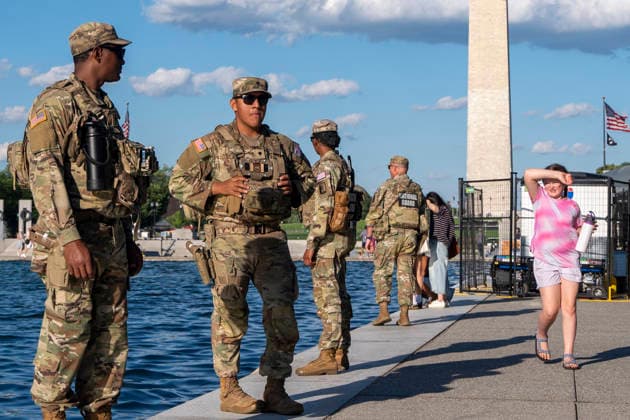 The reflecting pool in Washington - 19 Jun 2026 A girl looks at National Guard who are standing watch in front of paint peeling off the bottom of the Reflecting Pool in Washington. Washington United States Copyright: xJenxGolbeckx xSOPAxImagesx _1JG6750