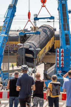 Schweres Güterzug-Unglück in München, Bergung eines Waggons, der von der Brücke gestürzt ist, Samstagmittag, München, 20.. Juni 2026 Deutschland, München, 20. Juni 2026, schweres Güterzug-Unglück in München, ein Toter, zwei Kräne bergen einen Waggon, der in der Nacht von der Brücke gestürzt ist, Schaulustige verfolgen die Bergungsarbeiten am Samstagmittag, das Zugunglück hatte sich nachts um 1:40 Uhr ereignet, zwei Güterzüge stießen beim Rangieren zusammen, Waggons stürzten von der Brücke, ein Mensch wurde tödlich verletzt, die Schleißheimer Straße, ist in diesem Bereich gesperrt, Milbertshofen, Verkehr, Bahn, Bayern, *** Serious freight train accident in Munich; recovery of a railcar that fell off a bridge; Saturday a