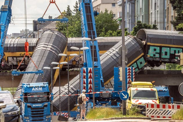 Schweres Güterzug-Unglück in München, Bergung eines Waggons, der von der Brücke gestürzt ist, Samstagmittag, München, 20.. Juni 2026 Deutschland, München, 20. Juni 2026, schweres Güterzug-Unglück in München, ein Toter, zwei Kräne bergen einen Waggon, der in der Nacht von der Brücke gestürzt ist, Schaulustige verfolgen die Bergungsarbeiten am Samstagmittag, das Zugunglück hatte sich nachts um 1:40 Uhr ereignet, zwei Güterzüge stießen beim Rangieren zusammen, Waggons stürzten von der Brücke, ein Mensch wurde tödlich verletzt, die Schleißheimer Straße, ist in diesem Bereich gesperrt, Milbertshofen, Verkehr, Bahn, Bayern, *** Serious freight train accident in Munich; recovery of a railcar that fell off a bridge; Saturday a