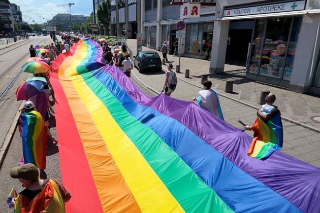 Teilnehmende tragen beim Christopher Street Day (CSD) in Ulm und Neu-Ulm eine ueber 100 Meter lange und 4,2 Meter breite Regenbogenfahne (Foto vom 20.06.2026). Die Veranstalter bezeichnen sie als die groesste Regenbogenfahne Deutschlands. Der CSD steht in diesem Jahr unter dem Motto Von Ufer zu Ufer: Wir halten zusammen! und findet zum 15. Mal statt. EDITORIAL USE ONLY *** Participants at Christopher Street Day (CSD) in Ulm and Neu Ulm are carrying a rainbow flag over 100 meters long and 4.2-meter-wide rainbow flag. Photo taken on June 20, 2026. The organizers describe it as Germany’s largest rainbow flag. This year’s CSD is themed From Shore to Shore Copyright: epd-bild ThomasxHeckmann 3 - Kopieren