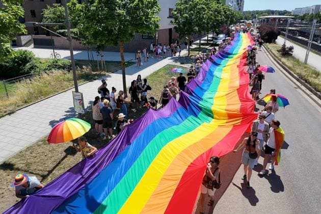 Teilnehmende tragen beim Christopher Street Day (CSD) in Ulm und Neu-Ulm eine ueber 100 Meter lange und 4,2 Meter breite Regenbogenfahne (Foto vom 20.06.2026). Die Veranstalter bezeichnen sie als die groesste Regenbogenfahne Deutschlands. Der CSD steht in diesem Jahr unter dem Motto Von Ufer zu Ufer: Wir halten zusammen! und findet zum 15. Mal statt. EDITORIAL USE ONLY *** Participants at Christopher Street Day (CSD) in Ulm and Neu Ulm are carrying a rainbow flag over 100 meters long and 4.2-meter-wide rainbow flag. Photo taken on June 20, 2026. The organizers describe it as Germany’s largest rainbow flag. This year’s CSD is themed From Shore to Shore Copyright: epd-bild ThomasxHeckmann 4 - Kopieren
