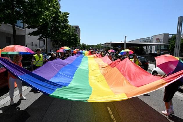 Teilnehmende tragen beim Christopher Street Day (CSD) in Ulm und Neu-Ulm eine ueber 100 Meter lange und 4,2 Meter breite Regenbogenfahne (Foto vom 20.06.2026). Die Veranstalter bezeichnen sie als die groesste Regenbogenfahne Deutschlands. Der CSD steht in diesem Jahr unter dem Motto Von Ufer zu Ufer: Wir halten zusammen! und findet zum 15. Mal statt. EDITORIAL USE ONLY *** Participants at Christopher Street Day (CSD) in Ulm and Neu Ulm are carrying a rainbow flag over 100 meters long and 4.2-meter-wide rainbow flag. Photo taken on June 20, 2026. The organizers describe it as Germany’s largest rainbow flag. This year’s CSD is themed From Shore to Shore Copyright: epd-bild ThomasxHeckmann 6 - Kopieren