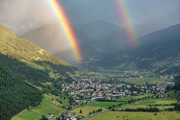 Luftaufnahme des österreichischen Kurorts Bad Hofgastein im Gasteinertal, über dem sich ein markanter Doppelregenbogen vor einer alpinen Bergkulisse erstreckt. Regenbogen im Gasteinertal *** Aerial view of the Austrian resort town of Bad Hofgastein in the Gastein Valley, with a striking double rainbow arching over it against an alpine mountain backdrop Rainbow in the Gastein Valley,detected_source_language