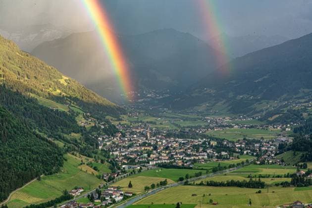Luftaufnahme des österreichischen Kurorts Bad Hofgastein im Gasteinertal, über dem sich ein markanter Doppelregenbogen vor einer alpinen Bergkulisse erstreckt. Regenbogen im Gasteinertal *** Aerial view of the Austrian resort town of Bad Hofgastein in the Gastein Valley, with a striking double rainbow arching over it against an alpine mountain backdrop Rainbow in the Gastein Valley,detected_source_language
