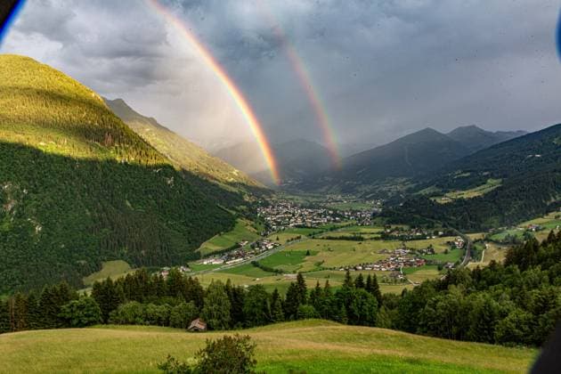 Luftaufnahme des österreichischen Kurorts Bad Hofgastein im Gasteinertal, über dem sich ein markanter Doppelregenbogen vor einer alpinen Bergkulisse erstreckt. Regenbogen im Gasteinertal *** Aerial view of the Austrian resort town of Bad Hofgastein in the Gastein Valley, with a striking double rainbow arching over it against an alpine mountain backdrop Rainbow in the Gastein Valley,detected_source_language