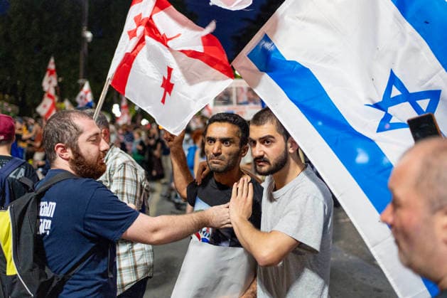 June 20, 2026, Tbilisi, Georgia: A free-Iran supporter holding an Israeli flag clash with a pro-Islamic regime of Iran supporter (not seen) as he and others participate on the 570th day of anti-government rallies in Tbilisi. Tbilisi Georgia - ZUMAz174 20260620_zip_z174_008 Copyright: xMoexZoyarix