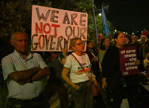 People hold a placard reading We Are Not Our Government at a protest against Israeli Prime Minister Benjamin Netanyahu in Jerusalem on Saturday, June 20, 2026. U.S. President Donald Trump has called on Prime Minister Netanyahu to stop the military strikes in Lebanon.  JER2026062016 DEBBIExHILL