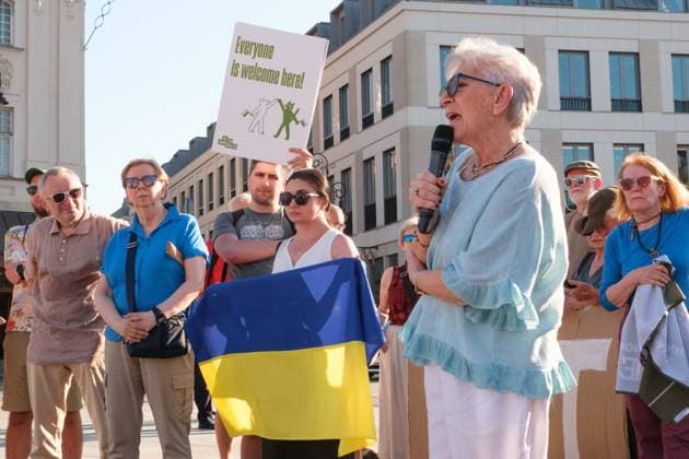 June 20, 2026, Warsaw, Masovian Voivodeship, Poland: A protester speaks as a woman holds a Ukrainian flag during a demonstration on Warsaw s Castle Square for World Refugee Day. Organized under the slogan open republic, the rally was held in protest against growing xenophobia towards migrants and refugees in Poland, as well as the increasing use of anti-migrant rhetoric by Polish conservatives and far-right politicians. Warsaw Poland - ZUMAk204 20260620_zip_k204_033 Copyright: xRomanxKozielx