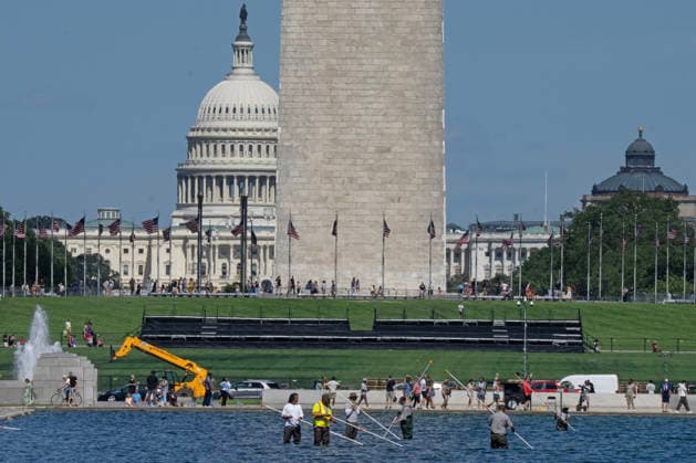 National Park Service workers use vacuum pumps to clean algae off the bottom of the newly renovated Lincoln Memorial Reflecting Pool on the National Mall in Washington, DC on Saturday, June 20,2026. The Trump Administration awarded no-bid contracts totaling nearly $15 million to renovated Reflecting Pool but it is now filled with algae and the paint is peeling. Dozens of National Guard and other police stop people from taking the blue paint chips floating in the water, with some arrests.  WAP2026062011 PATxBENIC
