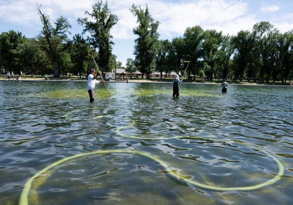 National Park Service workers use vacuum pumps to clean algae off the bottom of the newly renovated Lincoln Memorial Reflecting Pool on the National Mall in Washington, DC on Saturday, June 20,2026. The Trump Administration awarded no-bid contracts totaling nearly $15 million to renovated Reflecting Pool but it is now filled with algae and the paint is pealing. Dozens of National Guard and other police stop people from taking the blue paint chips floating in the water, with some arrests.  WAP2026062014 PATxBENIC