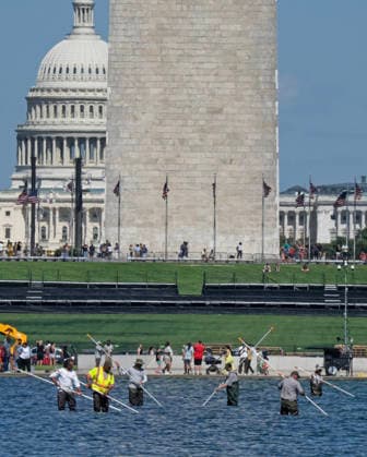 National Park Service workers use vacuum pumps to clean algae off the bottom of the newly renovated Lincoln Memorial Reflecting Pool on the National Mall in Washington, DC on Saturday, June 20,2026. The Trump Administration awarded no-bid contracts totaling nearly $15 million to renovated Reflecting Pool but it is now filled with algae and the paint is peeling. Dozens of National Guard and other police stop people from taking the blue paint chips floating in the water, with some arrests.  WAP202606200921 PATxBENIC