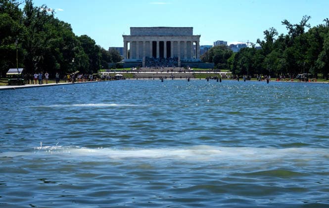 Hydrogen Peroxide is pumped into the newly renovated Lincoln Memorial Reflecting Pool to clean algae on the National Mall in Washington, DC on Saturday, June 20,2026. The Trump Administration awarded no-bid contracts totaling nearly $15 million to renovated Reflecting Pool but it is now filled with algae and the paint is peeling. Dozens of National Guard and other police stop people from taking the blue paint chips floating in the water, with some arrests.  WAP2026062015 PATxBENIC