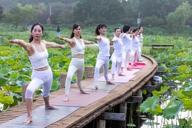 International Day Of Yoga TAIZHOU, CHINA - JUNE 21, 2026 - Yoga enthusiasts are practicing yoga on the walkway of the lotus pond at Tiande Lake in Taizhou City, Jiangsu Province, China on June 21, 2026. Taizhou Jiangsu China  Copyright: xCFOTOx i1782035449234