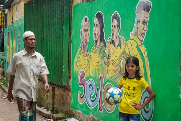 June 21, 2026, Chittagong, Chittagong, Bangladesh: Children gather around FIFA World Cup 2026-themed murals, posing with footballs, reenacting iconic celebrations and mimicking their favourite players. Painted on the walls of a residential neighbourhood, the murals have become a focal point for local youngsters, reflecting how football fever reaches beyond the pitch and brings communities together through shared passion and play. Chittagong Bangladesh - ZUMAs356 20260621_zip_s356_004 Copyright: xMohammedxSumanx