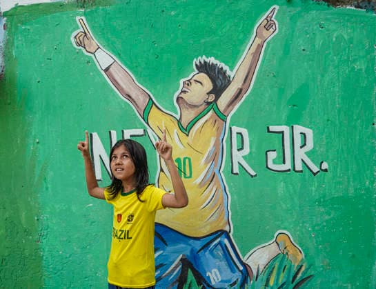 June 21, 2026, Chittagong, Chittagong, Bangladesh: Children gather around FIFA World Cup 2026-themed murals, posing with footballs, reenacting iconic celebrations and mimicking their favourite players. Painted on the walls of a residential neighbourhood, the murals have become a focal point for local youngsters, reflecting how football fever reaches beyond the pitch and brings communities together through shared passion and play. Chittagong Bangladesh - ZUMAs356 20260621_zip_s356_014 Copyright: xMohammedxSumanx