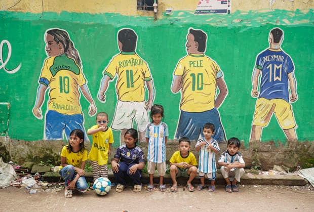 June 21, 2026, Chittagong, Chittagong, Bangladesh: Children gather around FIFA World Cup 2026-themed murals, posing with footballs, reenacting iconic celebrations and mimicking their favourite players. Painted on the walls of a residential neighbourhood, the murals have become a focal point for local youngsters, reflecting how football fever reaches beyond the pitch and brings communities together through shared passion and play. Chittagong Bangladesh - ZUMAs356 20260621_zip_s356_018 Copyright: xMohammedxSumanx