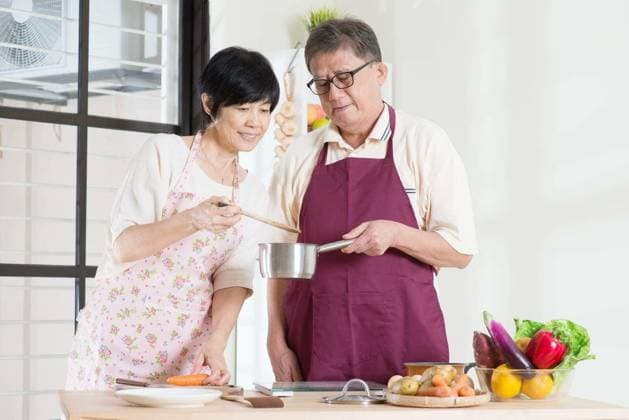 Asian mature couple cooking food at kitchen. Seniors living lifestyle at home. model released Symbolfoto Copyright: xszefeix Panthermedia72466876.jpg