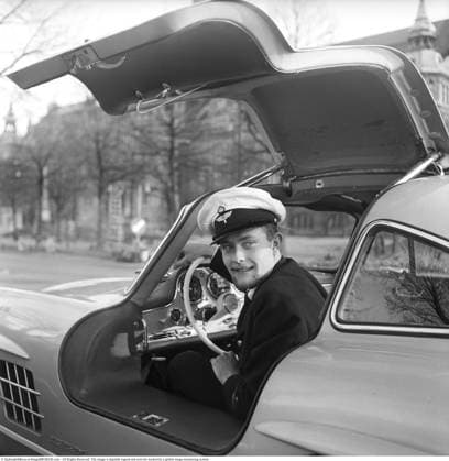 Ulf Norinder (19. Mai 1934 – 14. November 1978) war ein schillernder schwedischer Rennfahrer und wohlhabender Erbe eines Holz und Grundstücksvermögens.Von den 1950er bis in die 1970er Jahre trat er als Privatfahrer im Sportwagenrennsport an und fuhr Fahrzeuge wie Maserati, Porsche, Ferrari (darunter einen 250 GTO), Lola und andere bei Veranstaltungen wie der Targa Florio, Le Mans und Läufen der Sportwagen Weltmeisterschaft. Bekannt für seine extravagante Persönlichkeit und seinen überlebensgroßen Stil, trat er oft gemeinsam mit seinem Landsmann Jo Bonnier an. Auf dem Foto ist er in seinem Mercedes Benz 300 SL (wahrscheinlich ein Modell von 1955, erkennbar an den angeschraubten Radlaufkanten) zu sehen, der auf der Straße vor dem Nordischen Copyright: imageBROKER Sjoberg ibljsj18096316.jpg