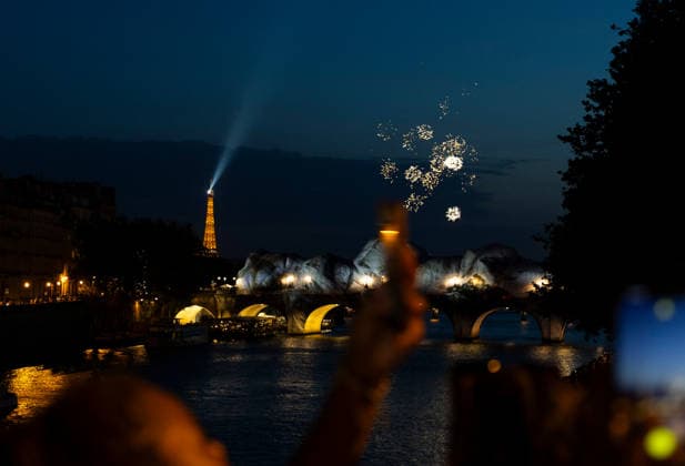 (260622) -- PARIS, June 22, 2026 -- People take photos of fireworks near Pont Neuf bridge over the Seine River in Paris, France, June 21, 2026. France celebrated its annual Fete de la Musique (music day) on Sunday. Amid hot weather, many residents and tourists gathered along the banks of the Seine River in Paris to relax and escape the heat. ) FRANCE-PARIS-SUMMER-DAILY LIFE WuxHuiwo 